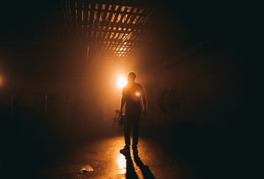 a man standing in a dark room with a light shining on his face