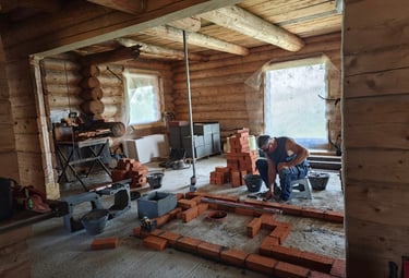Construcția unei sobe din cărămidă într-o casă de lemn – meșter sobar la lucru.