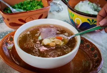 Consomé tradicional de barbacoa con garbanzos servido en plato artesanal en Querétaro.