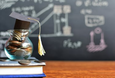 Jar of coins and books on desk with chalkboard background