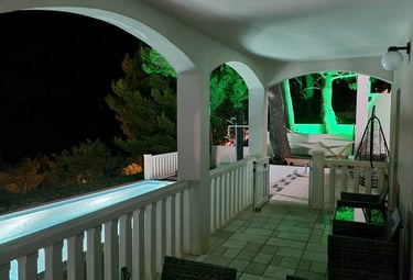 The photograph depicts the balcony and a part of the courtyard at night.