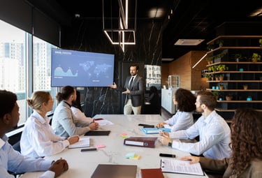 A consultant explaining global strategy on a large screen to the serior management team