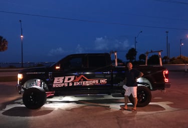 a man standing next to a truck with a truck in the background