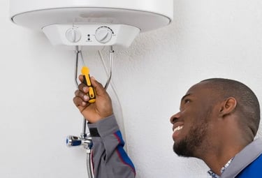 Professional plumber repairing an electric water heater unit with a handheld tool.