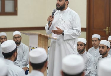 A teacher gently guiding a young student through Islamic character lessons.