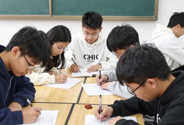 A small group of attentive students working together on physics problems in a clean classroom.