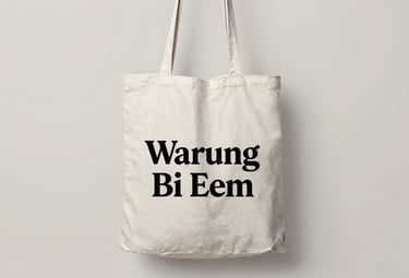 A high-quality studio shot of a canvas tote bag with a minimalist retro logo of Warung Bi Eem. Soft lighting on a #F0E5D0 background, sophisticated 90s vibe.