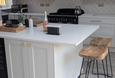 white image, with wooden stools, pink champagne on the countertop, with hidable popout outlets