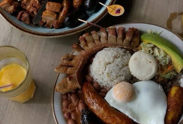 Authentic Colombian Bandeja Paisa with fried egg, chorizo, crispy pork belly, beans, and rice.