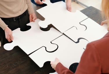 Business team qui collaborent pour assembler un large puzzle blanc