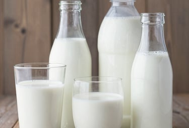Freshly baked golden loaves of bread and a variety of cakes displayed on a bakery counter.
