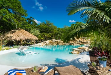  Beach-entry lagoon pool with pale blue water and sand-toned interior creating a tropical, resort-st