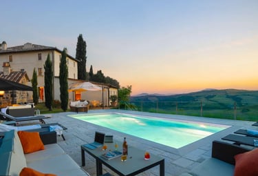 Modern Tuscan-style home with Rectangular pool with pale blue water and light stone tiling