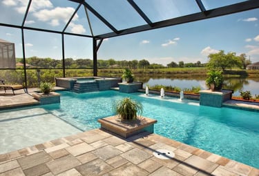 Geometric pool with clear blue water, light stone tiling within a lanai enclosure