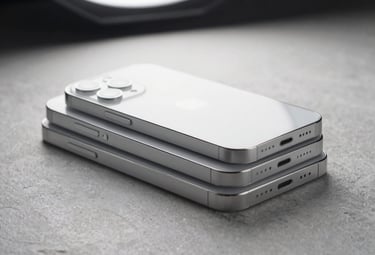 A modern, minimalist close-up photograph of silver smartphones stacked cleanly on a soft light gray stone surface. Professional studio setup with sharp contrasts, soft overhead white lighting.