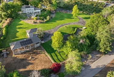 a house with a large lawn and gardens