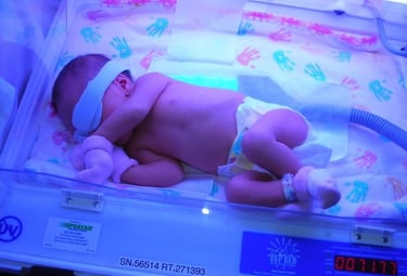 Newborn baby receiving phototherapy treatment for jaundice in a hospital neonatal incubator.