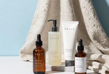 A bright photography studio in the US featuring ecommerce products like high-end skincare bottles and linen textiles arranged aesthetically on a white surface with Sky Blue accents.