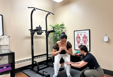 Chiropractor correcting patient's knee position in a squat.