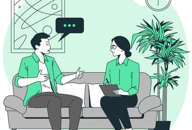 a man and woman sitting on a couch talking in a therapy session