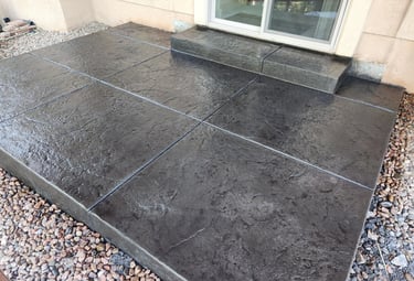 a colored and stamped concrete patio and a step with old granite texture stamp.
