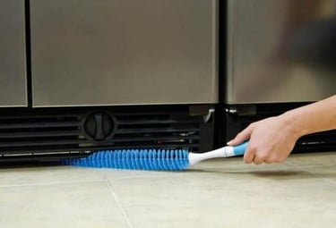 a person cleaning a kitchen floor with a brush