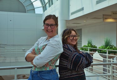 Two young college women best friends smiling and laughing in the camera.