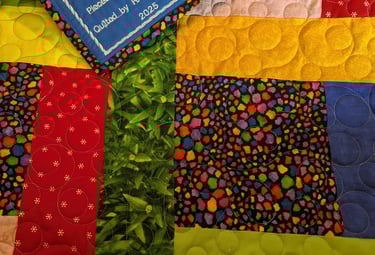 a colorful quilt with part of an embroidered label visible