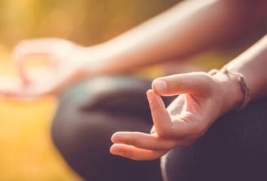 a person sitting in a lotus position with their hands up