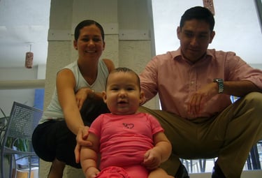 a man and woman sitting on a couch with a baby
