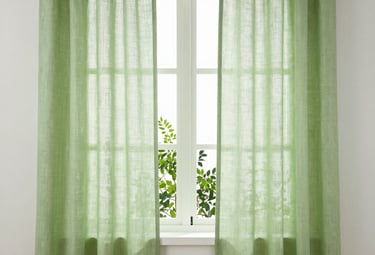 Elegant linen curtains softly filtering sunlight in a cozy room.