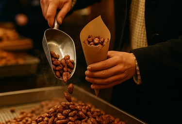 Gebrannte Mandeln werden auf einem Marktstand geschöpft, im Hintergrund warmes Licht und Gäste.