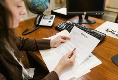 a woman sitting at a desk with a pen and paper