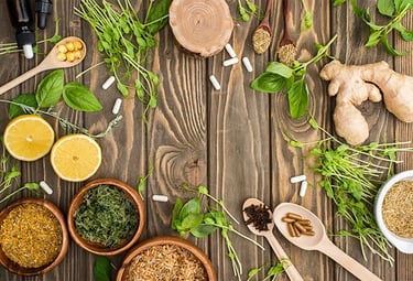 a variety of herbs and spices in bowls on a wooden table