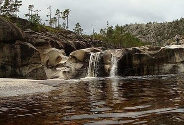 Water with a rock formation and a waterfall-flikr-cite