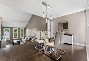 a dining room with a glass table and chairs