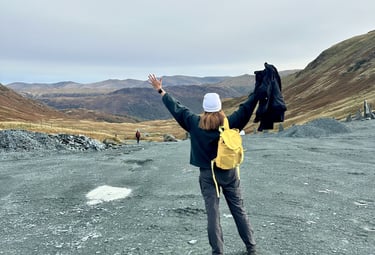 Coach Moll facing mountain view with arms raised