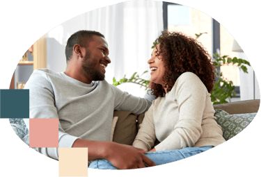 a man and woman sitting on a couch laughing with each other