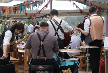 High-energy Devon ceilidh band Rowans leading a festival-style barn dance at a summer wedding