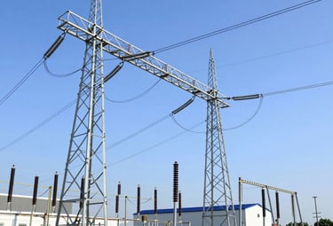 Wind turbines spinning against a vibrant sunset over an industrial landscape.