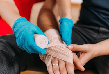 Close up image of a person bandaging someone's hand