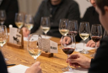 Elegant wine glasses filled with red wine against a minimalist black and burgundy backdrop.