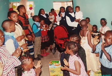Catholic nuns celebrating with children at an African orphanage or community center gathering.