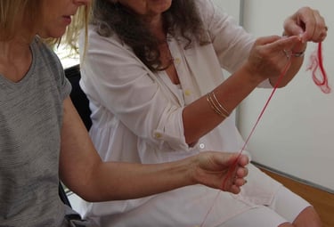 Instructor showing a student how to spin yarn