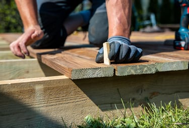 handyman repairing outdoor decking boards at an Auckland home