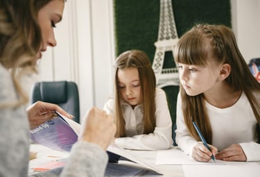 UKG home tutor teaching child at home with books and learning materials
