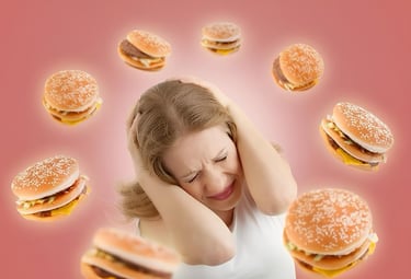  Mulher tapando os ouvidos cercada por hambúrgueres, simbolizando desejo por fast-food.
