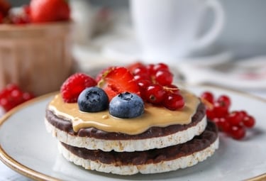 Chocolate rice cakes topped with peanut butter, fresh blueberries, strawberries, and red currants.