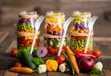 a variety of vegetables in mason jars with forks and forks