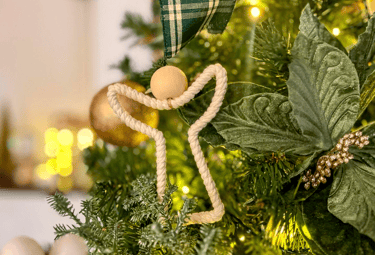 árvore de natal com um anjo ornamentado preso ao galho